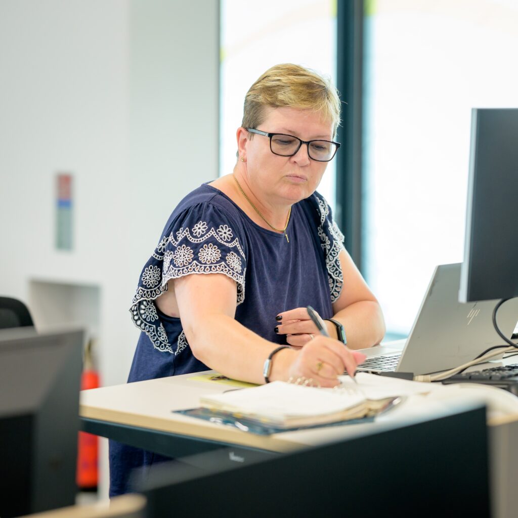 Woman writing about  the difference between bookkeeping and accounting