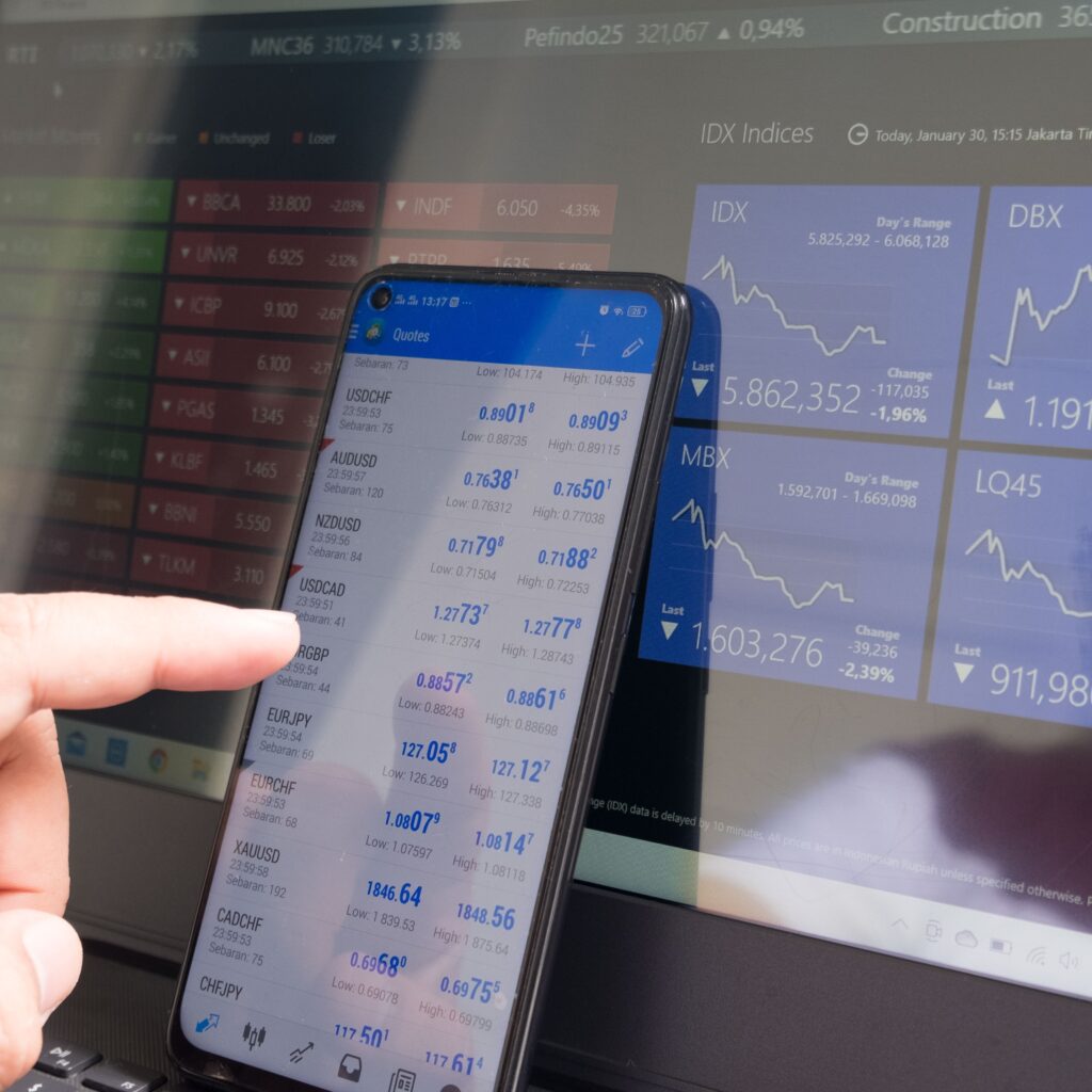 Person pointing to a phone screen eith the stock market on it