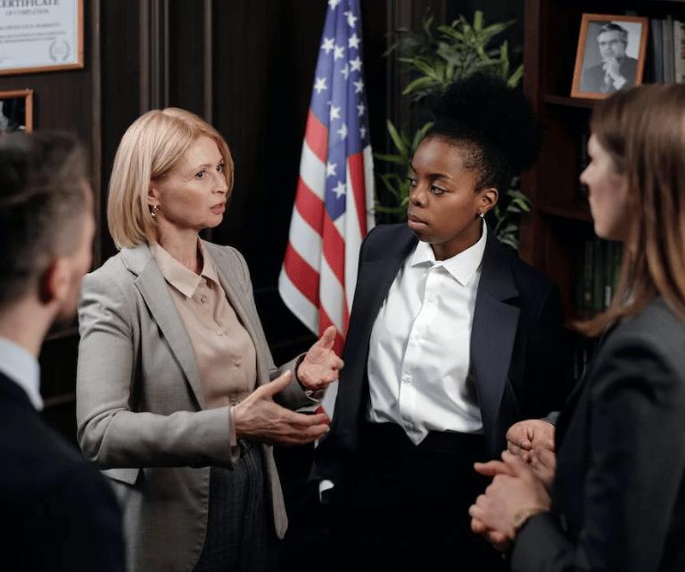 Three women talking. USA flag in the background