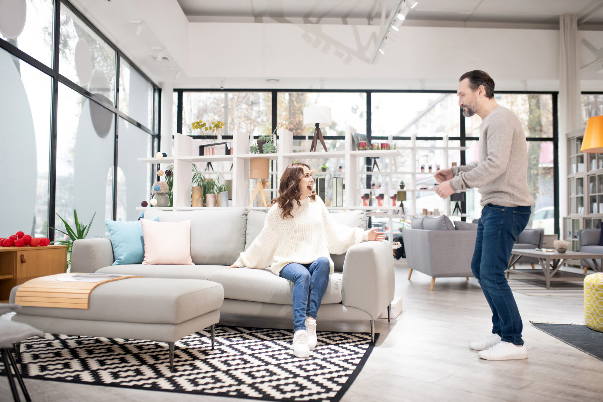 Couple discussing furniture models in a modern furniture shop