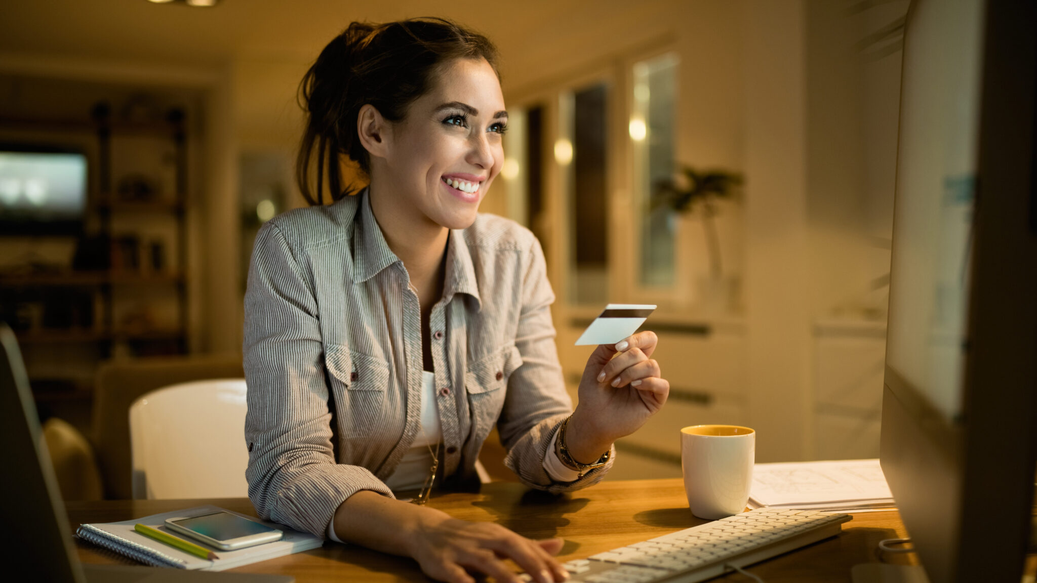 Young happy woman using credit card for online shopping.