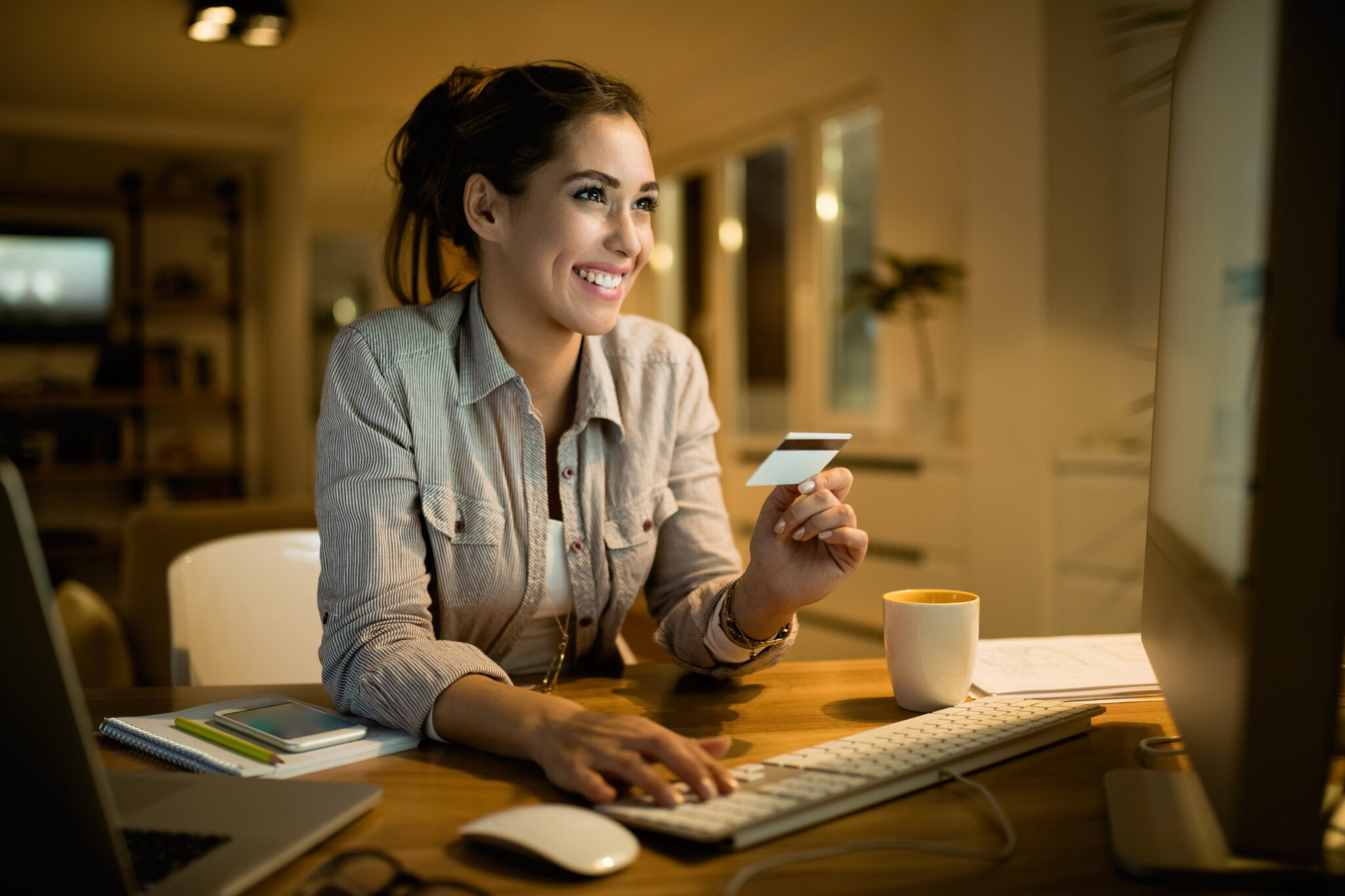 Mujer feliz usando su tarjeta de crédito para comprar en línea 