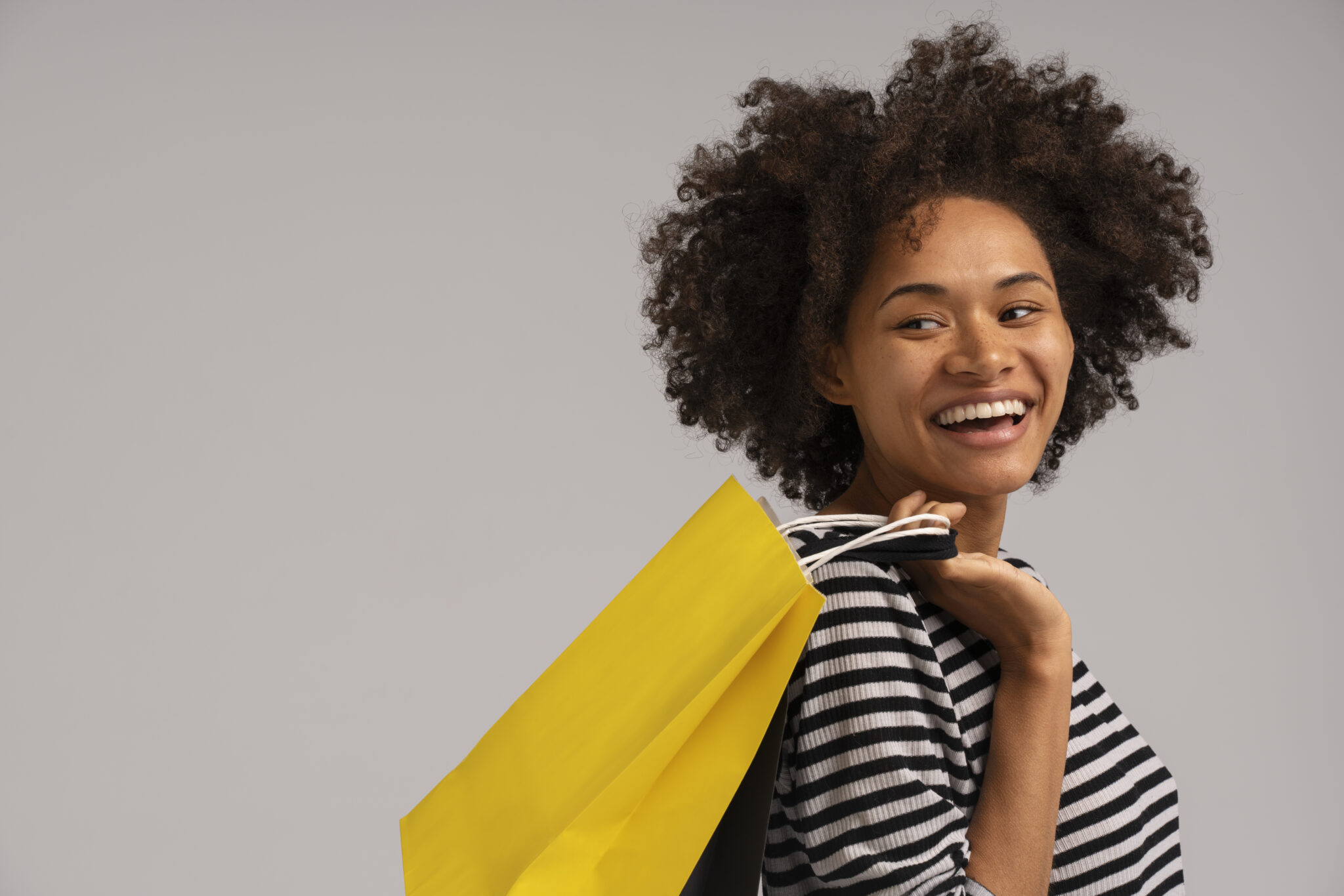 Mulher com sacola amarela fazendo compras na Black Friday 2023
